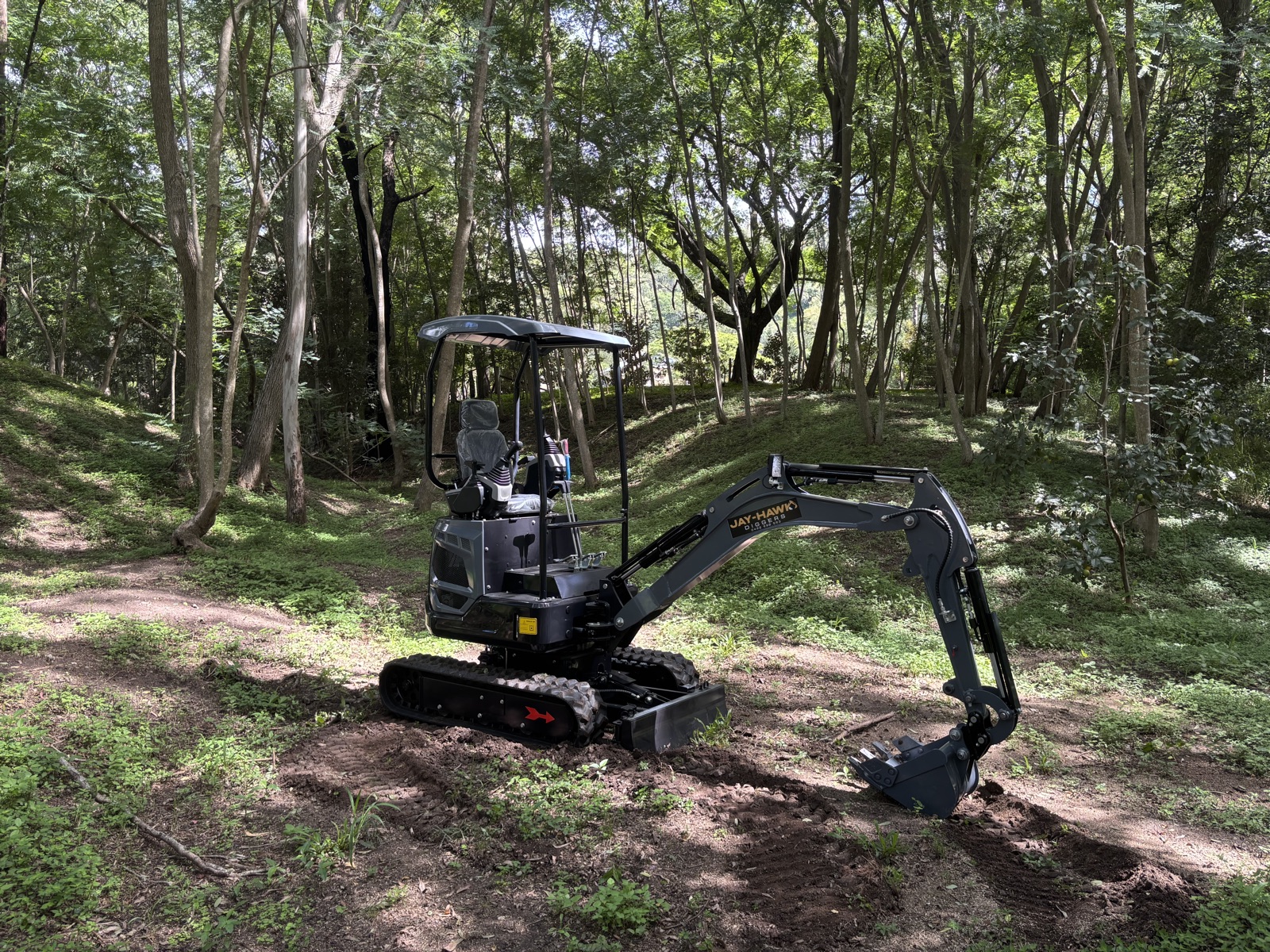 JHM18 PRO mini excavator in a forest clearing